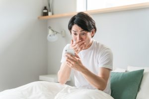 スマホを見て驚く男性